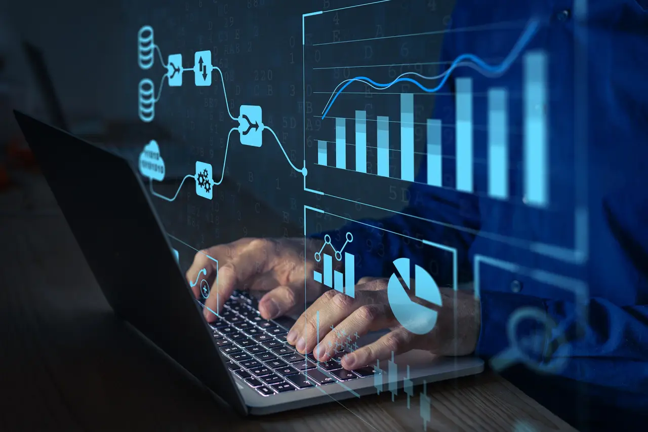 Mann arbeitet an Laptop mit digitalen Datenvisualisierungen und Diagrammen im Hintergrund
